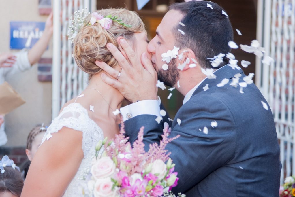 Baiser des mariés sous une pluie de pétales – photographe mariage Créteil