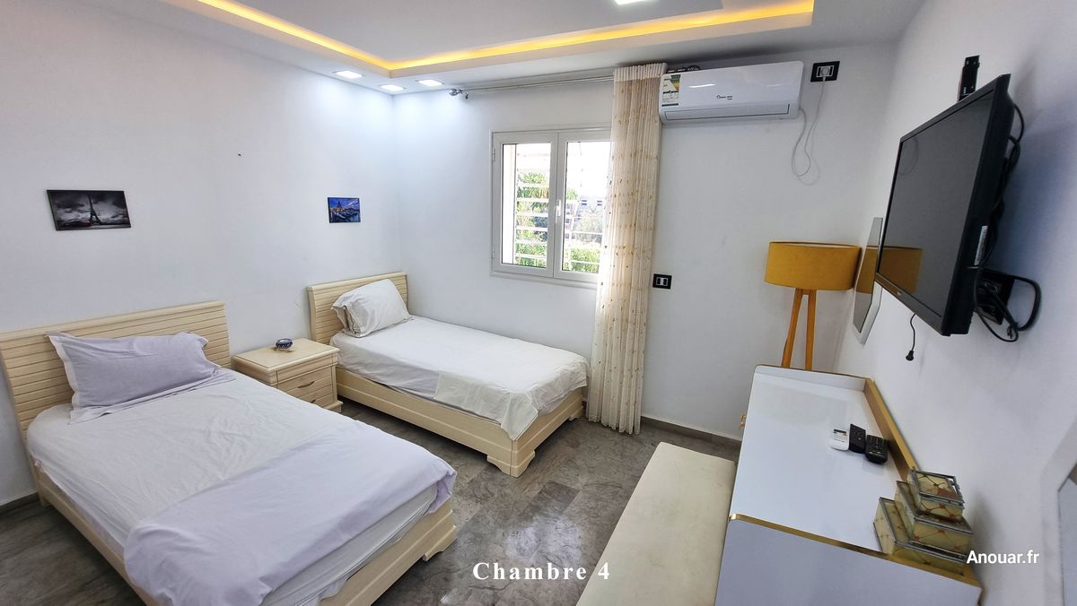 Chambre 4 avec deux lits simples et télévision