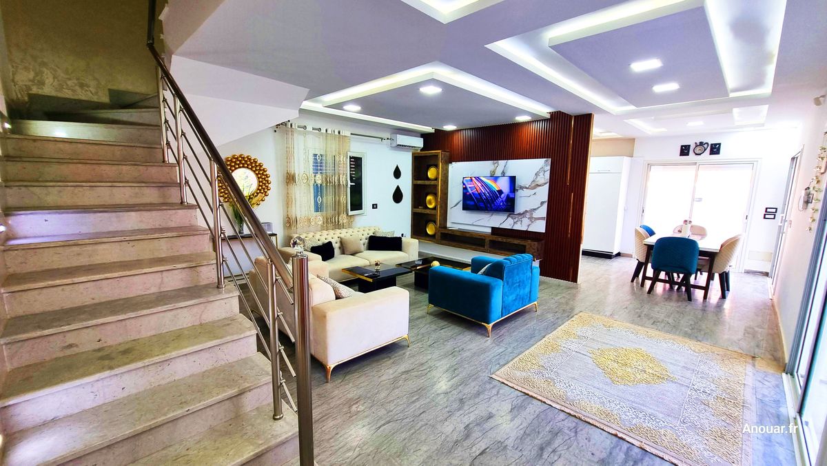 Location villa Djerba Houmt Souk avec piscine : salon, escalier et salle à manger
