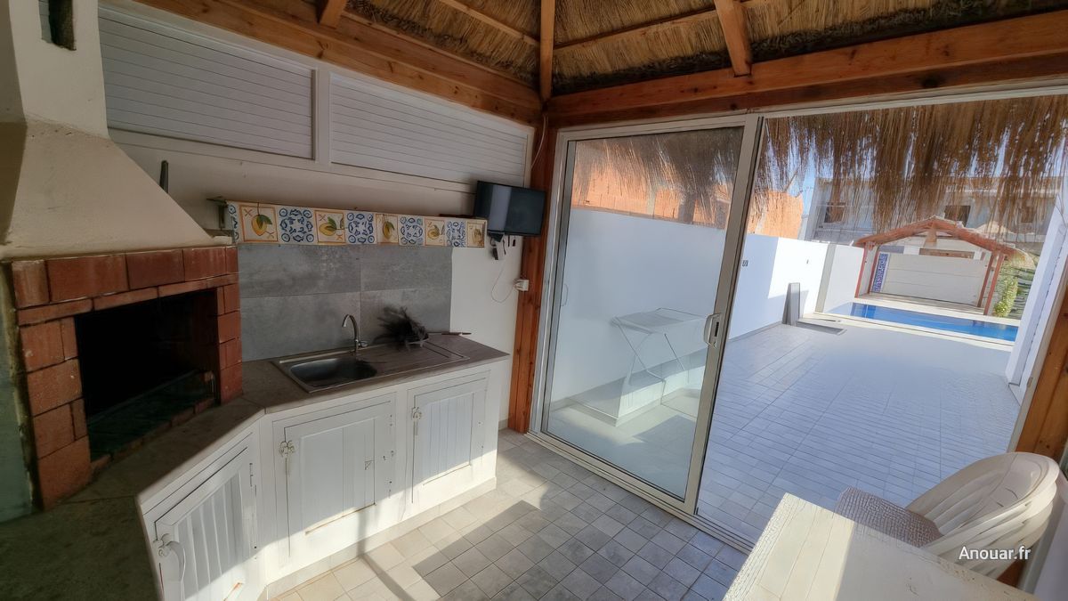 Intérieur de la paillote, coin ombragé avec barbecue et mini-cuisine