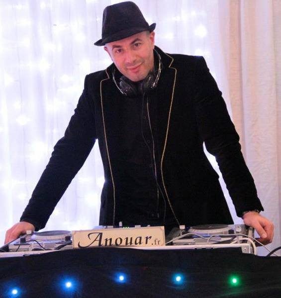 DJ oriental derrière sa cabine Anouar.fr devant un rideau lumineux